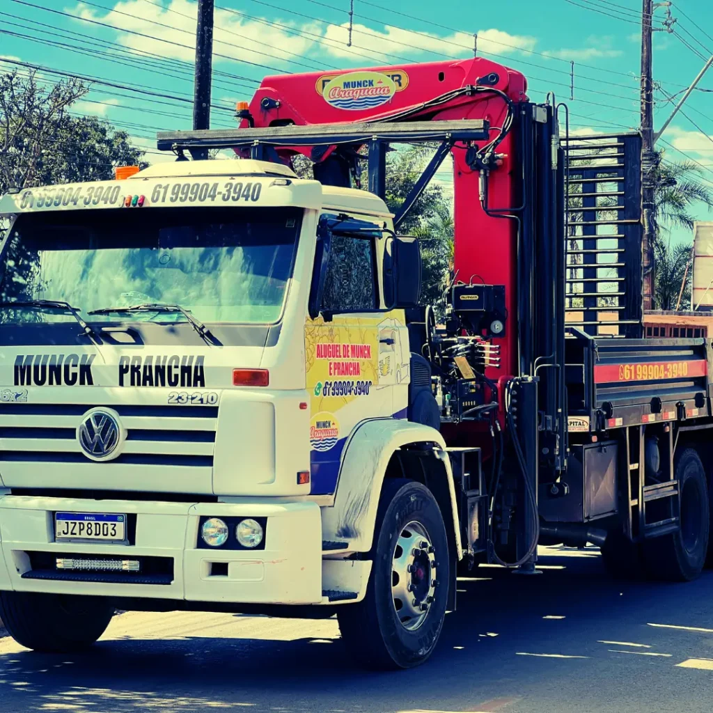Vista frontal de um caminhão branco para locação de caminhão munck em Brasília, com guindaste vermelho e adesivos da empresa Araguaia Munck.