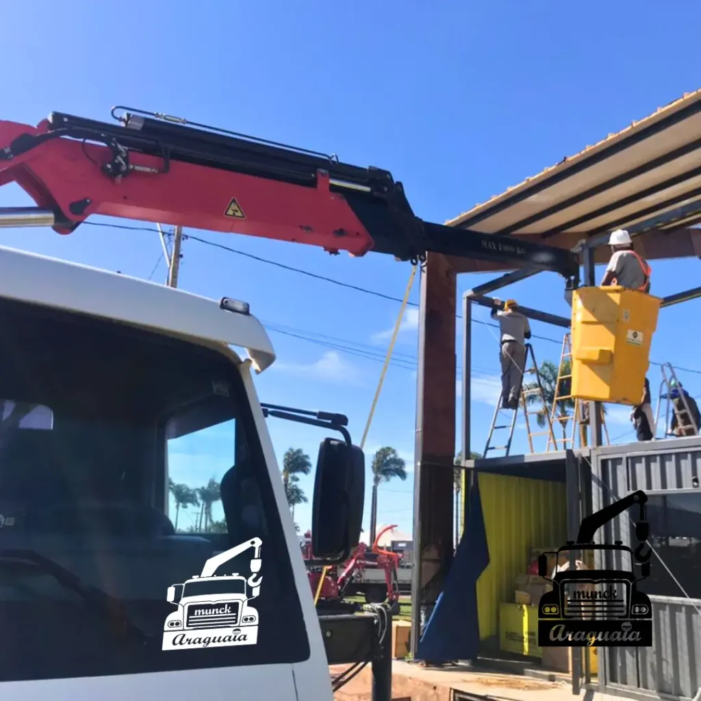 Caminhão munck com cesto aéreo realizando serviço em altura com operadores utilizando equipamentos de segurança, ideal para instalação e manutenção em estruturas elevadas. Locação de caminhão munck com cesto pela Munck Araguaia.